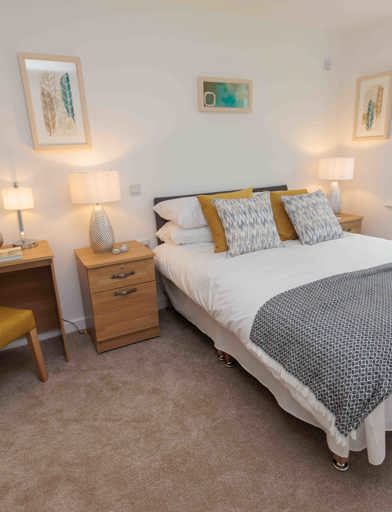 A photo of a bedroom with a double bed, side table and dressing table at Castlestead View 