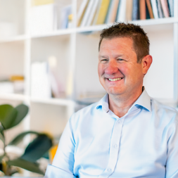Man in pale shirt smiling 