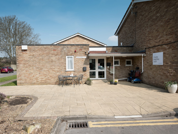 Main entrance to the scheme with patio area, tables and chairs