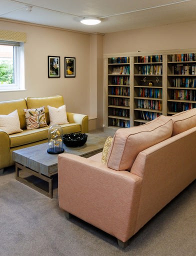 Communal lounge with sofas and a large set of bookshelves 