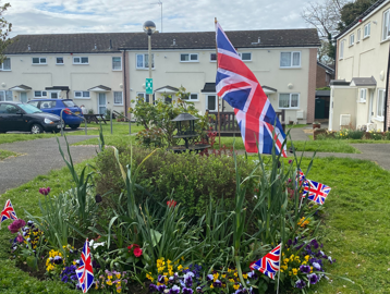 Circular bedding area in the front communal garden area decorated with Union Jack flags