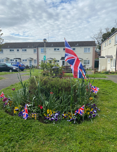 Circular bedding area in the front communal garden area decorated with Union Jack flags 