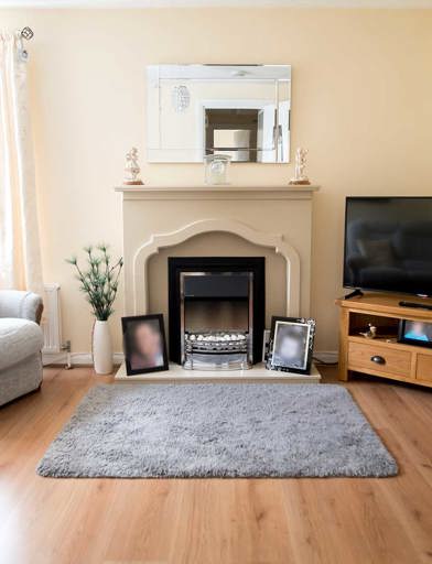 A living room with television, mantlepiece, sofas and large window