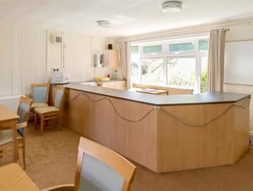 A small communal kitchen area with tables and seating