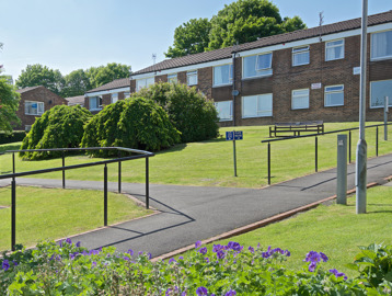 Pathway through the front gardens with flowers and bench