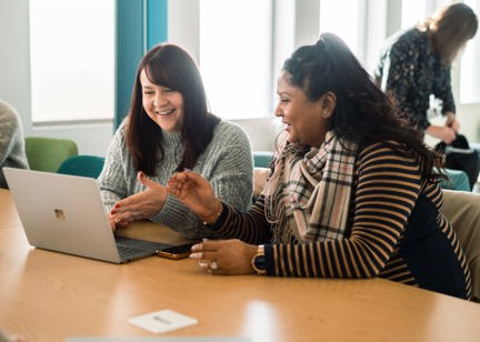 Corporate employees smiling looking at a laptop