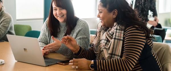 Corporate employees smiling looking at a laptop