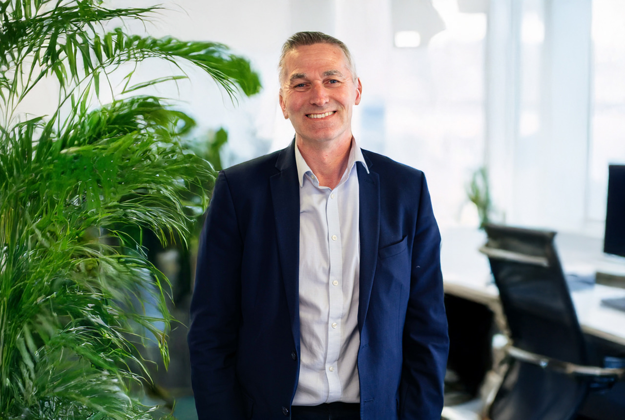 Smiling man wearing suit jacket and pale blue short