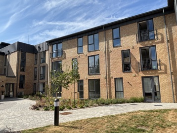 Outer building of South Hayling Court with a blocked path in front with grass and plants