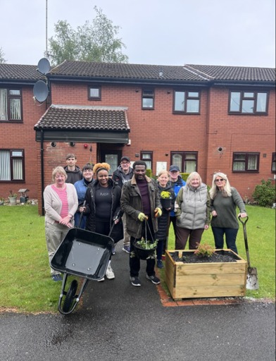 Residents and Volunteers at Sydney Jones Court help to plant new hanging baskets 