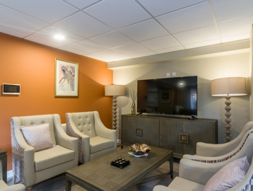 Miller Court Internal: communal living room with television set up central to four armchairs