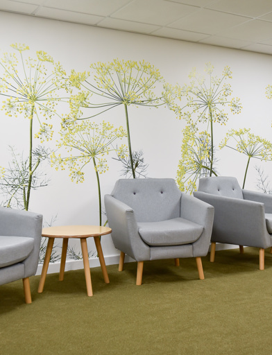 Communal area with soft seating and floral wallpaper inside Acre Court