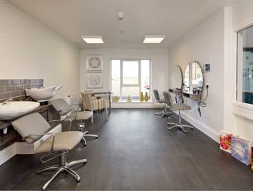 Inside the hair dressers at Filey Fields featuring hair wash basins, chairs and wall mirrors  