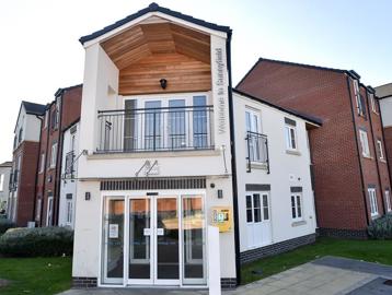 Main entrance to Sunnyfield Court with grassed areas either side