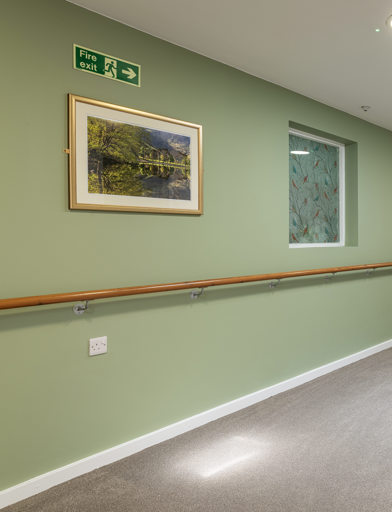 A green hallway with railings 
