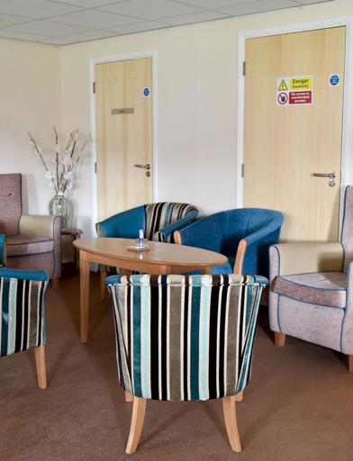 A communal seating area for residents with soft seated armchairs 