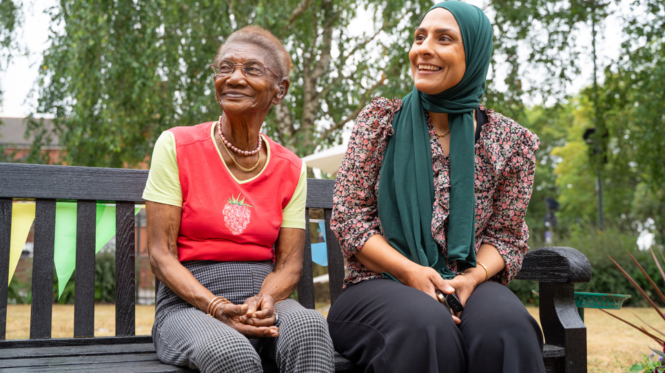 Two women smile into the distance