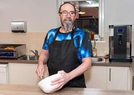 Resident with a mixing bowl in a kitchen