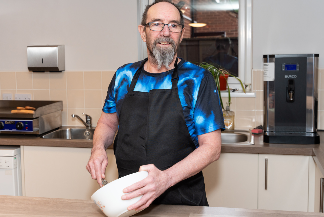 Resident with a mixing bowl in a kitchen