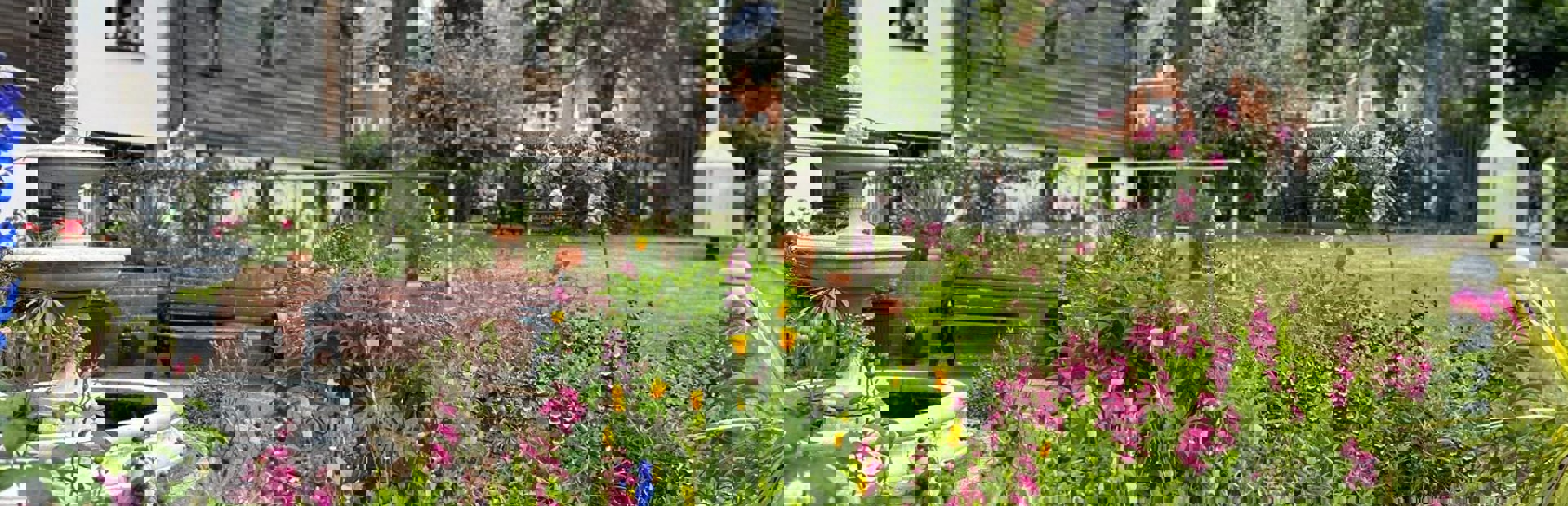 A close up photograph of the flowers and plants in the rear garden with water fountain and seating