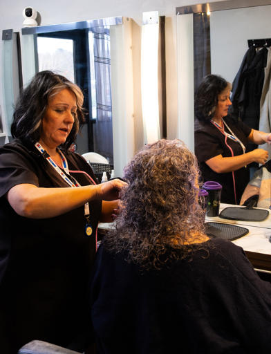 A resident having her hair styled at the on-site beauty salon 