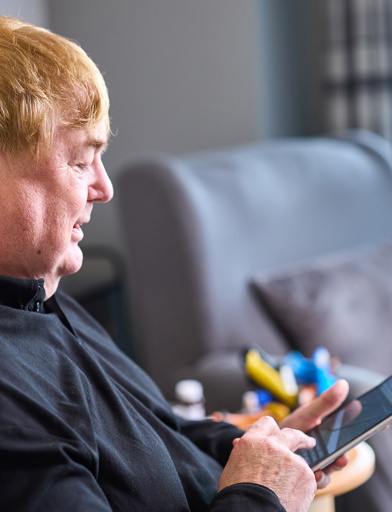 A male resident with a mobile phone in their hand 