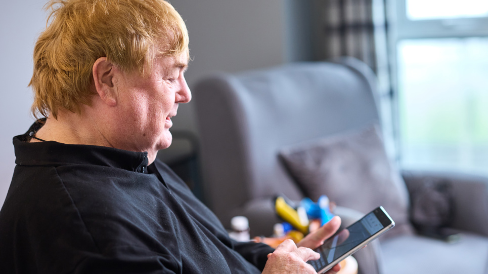 A male resident with a mobile phone in their hand