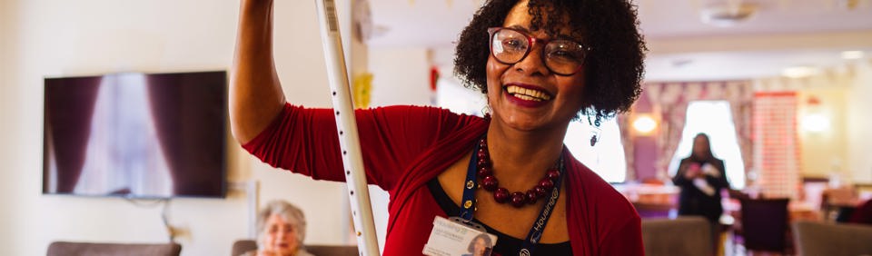 Employee smiling holding a walking stick  