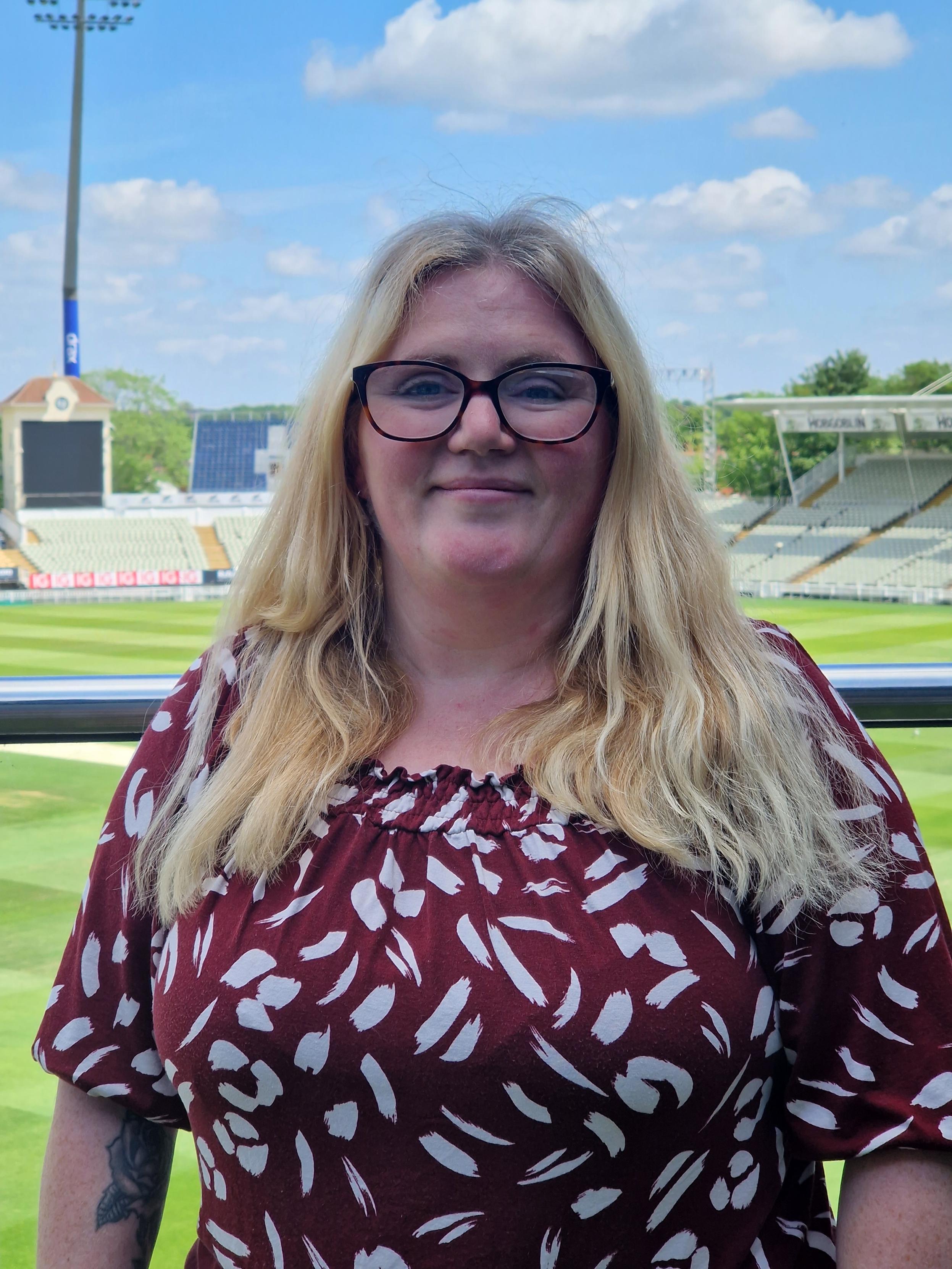 Employee, Rachel standing outside in a cricket ground