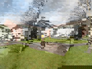 Wide-angle view of the garden area with path running through a lawned area with benches
