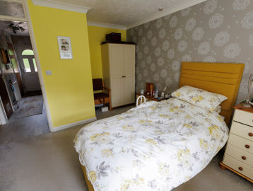 A bedroom that is yellow and grey