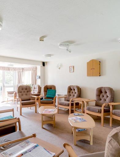 Chairs around the edge of the room in a residents' lounge 