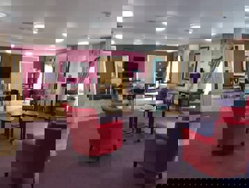 Communal lounge with seating, tables and TV