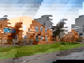 View of the scheme from the roadside with grass verge and trees