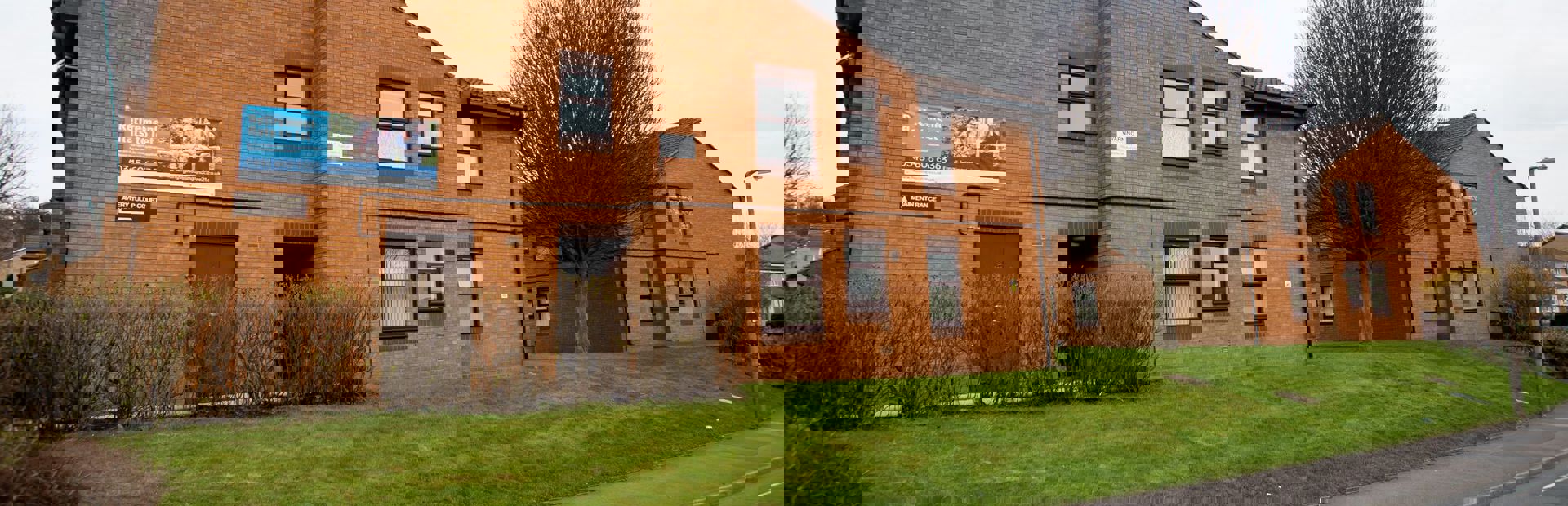 View of the scheme from the roadside with grass verge and trees