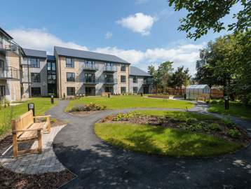 An image showing the outer building of Housing 21's Extra Care scheme, Bowland View surrounded by tree's and grass