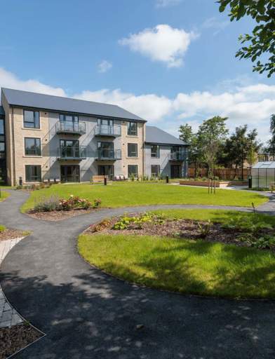 An image showing the outer building of Housing 21's Extra Care scheme, Bowland View surrounded by tree's and grass