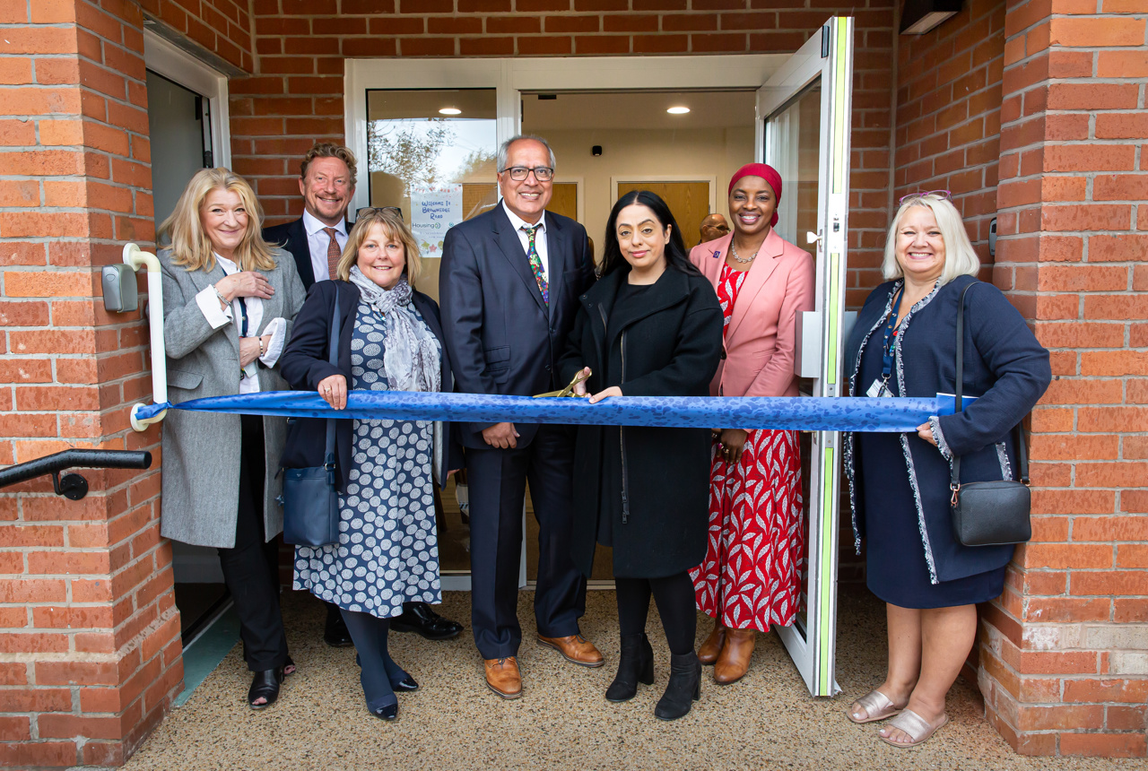 Housing 21 representatives with Councillor Arooj Shah, Leader of Oldham Council, standing outside the new community room door ahead of the ribbon cutting.