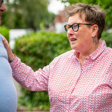 a woman holds a man's shoulder 