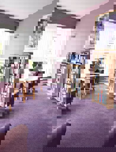 Communal library with soft seating in a purple colour theme