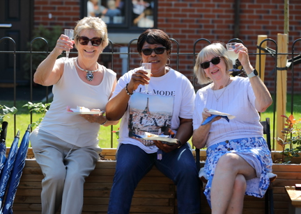 Residents friends smiling outside all holding a glass of prosecco 
