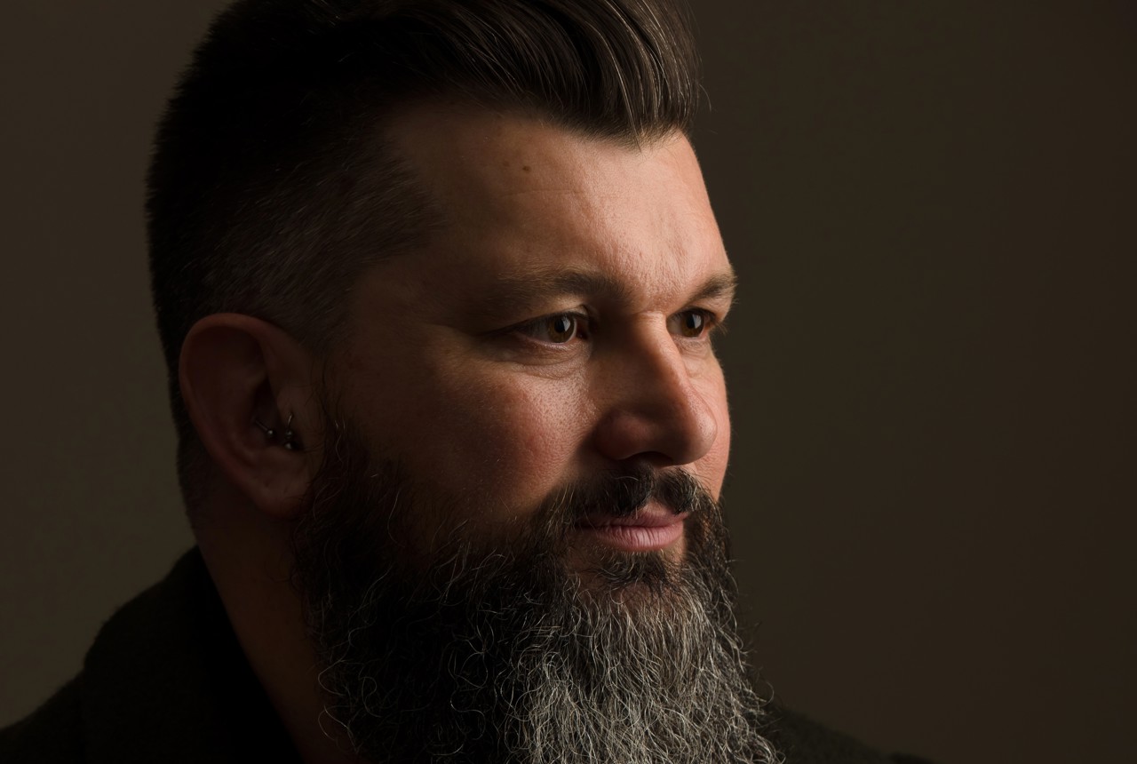 a bearded man looking beyond the camera
