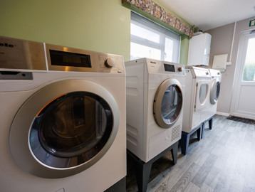 A laundry room containing washing machines and dryers