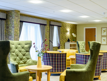 Communal area for residents with high-back soft seating and coffee tables