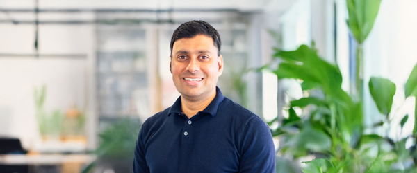 Man in dark blue shirt stood in an office 