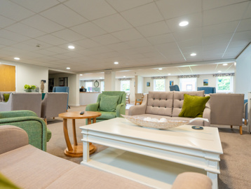 Bright and open communal living space with sofas and armchairs