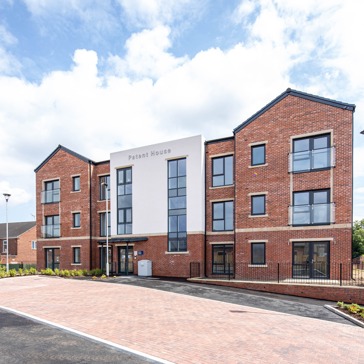 A three storey Retirement Living building with a car park at the entrance