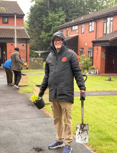 Gary from Manchester Council is getting wet helping in the garden 