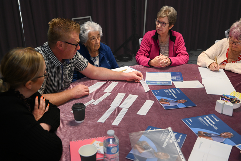 A table of residents taking part in a task as a team