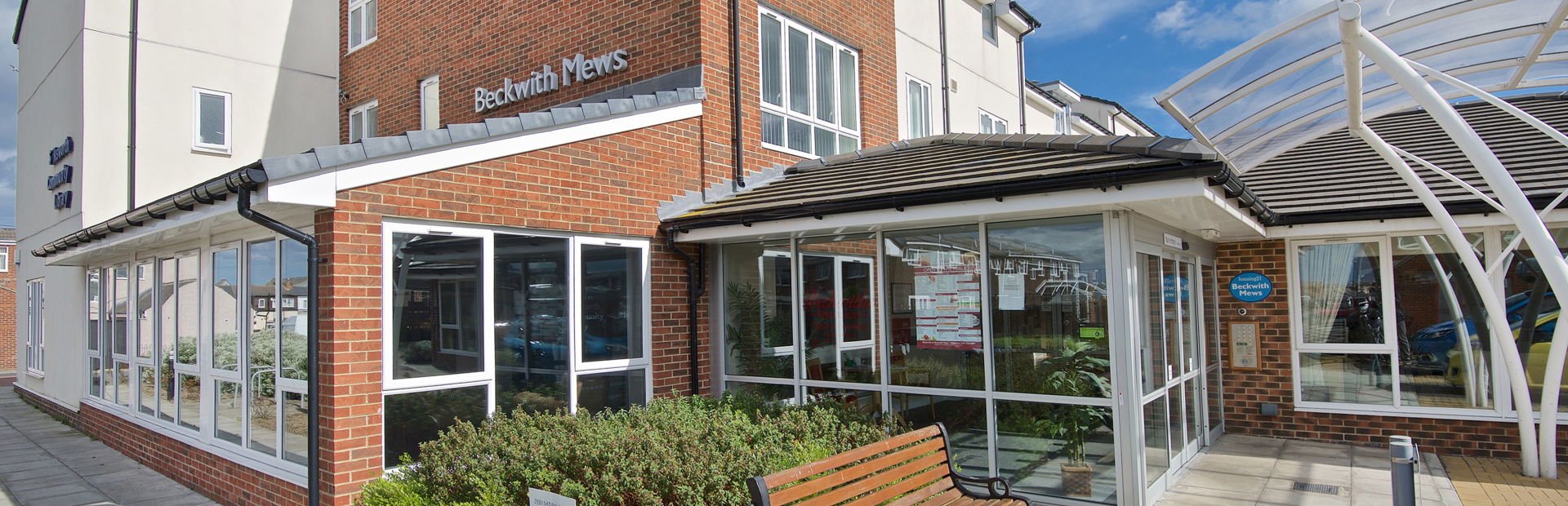 Front entrance to the scheme with bench and flower bed outside